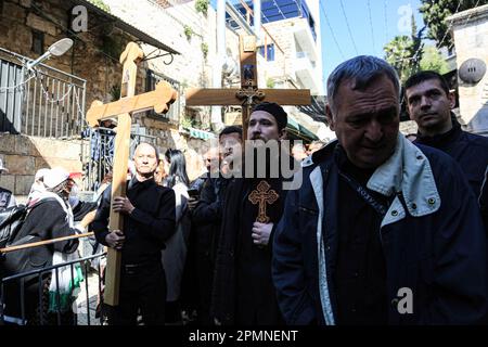 Gerusalemme est, Israele. 14th Apr, 2023. I cristiani ortodossi portano croci di legno lungo la Via dolorosa nella Città Vecchia di Gerusalemme durante la processione del Venerdì Santo ortodosso prima del Sabato Santo di domani. I pellegrini cristiani hanno partecipato alle processioni lungo il cammino, mentre, secondo la tradizione, Gesù Cristo ha portato la croce il suo ultimo giorno prima della crocifissione. (Foto di Saeed Qaq/SOPA Images/Sipa USA) Credit: Sipa USA/Alamy Live News Foto Stock