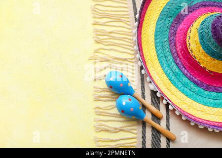 Maracas messicane con cappello sombrero e serape su sfondo giallo Foto Stock