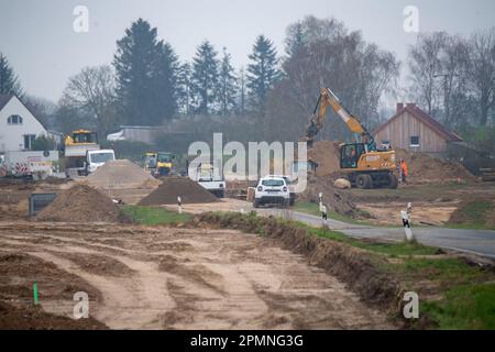 Sauzin, Germania. 14th Apr, 2023. I veicoli da costruzione lavorano sul cantiere per la circonvallazione B111 vicino Wolgast. Il nuovo ponte sull'isola di Usedom sul fiume Peene è da costruire a sud di Wolgast con una lunghezza di 1,4 chilometri, tralicci alti 70 metri e 42 metri di spazio tra il fiume Peene e il bordo inferiore del ponte. In totale, il progetto dovrebbe costare circa 140 milioni di euro. La città di Wolgast deve essere alleviata da un collegamento diretto tra l'autostrada 20 e l'isola di Usedom. Credit: Stefan Sauer/dpa/Alamy Live News Foto Stock