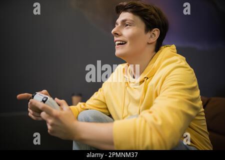 KIEV, UCRAINA - 13 FEBBRAIO 2023: Giovane uomo allegro che gioca il video gioco nel cyber club, immagine di riserva Foto Stock