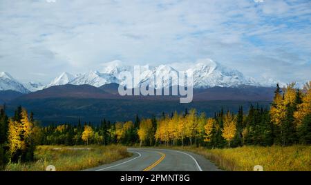 Un'autostrada tortuosa rivela una splendida vista autunnale delle Rainbow Ridge Mountains; Alaska, Stati Uniti d'America Foto Stock