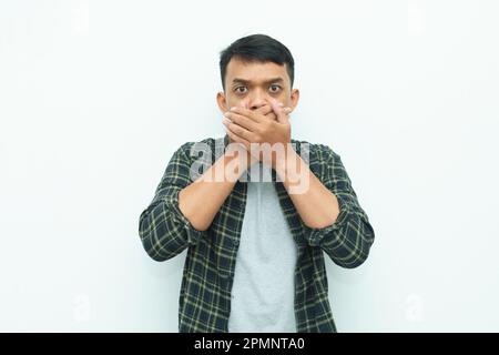 Giovane asiatico che gli copriva la bocca con le mani Foto Stock