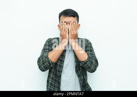 Giovane asiatico che copre il suo volto con le mani palme Foto Stock