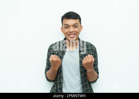 Giovane asiatico sorridente e mostrando sì o espressione di gesto di successo Foto Stock