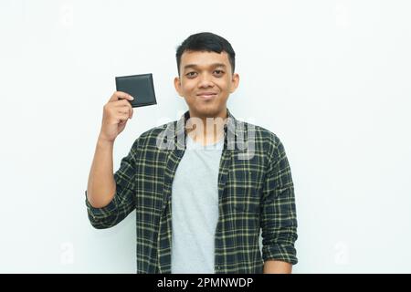 Giovane asiatico sorridente mentre tiene il portafoglio nero Foto Stock