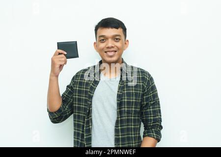 Giovane asiatico sorridente mentre tiene il portafoglio nero Foto Stock