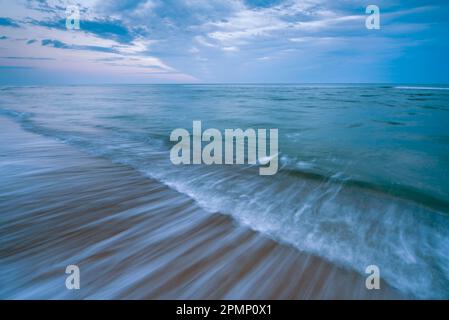 Surf fluendo su una spiaggia all'alba, Marconi Beach a Welfleet, Massachusetts, Stati Uniti; Massachusetts, Stati Uniti d'America Foto Stock