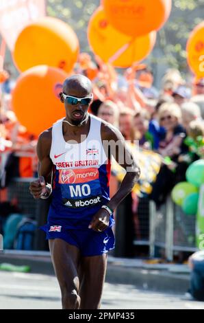 MO Farah gareggia nella Maratona di Londra 2014, passando attraverso Tower Hill vicino alla Torre di Londra, Regno Unito. Giubbotto Gran Bretagna, atleta britannico d'élite Foto Stock