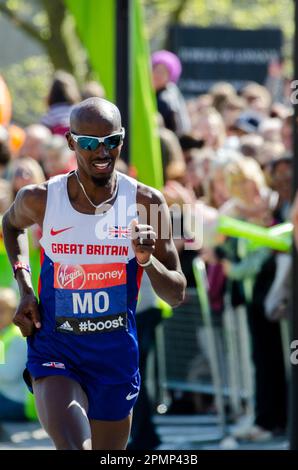 MO Farah gareggia nella Maratona di Londra 2014, passando attraverso Tower Hill vicino alla Torre di Londra, Regno Unito. Giubbotto Gran Bretagna, atleta britannico d'élite Foto Stock