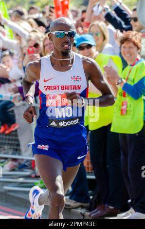 MO Farah gareggia nella Maratona di Londra 2014, passando attraverso Tower Hill vicino alla Torre di Londra, Regno Unito. Giubbotto Gran Bretagna, atleta britannico d'élite Foto Stock