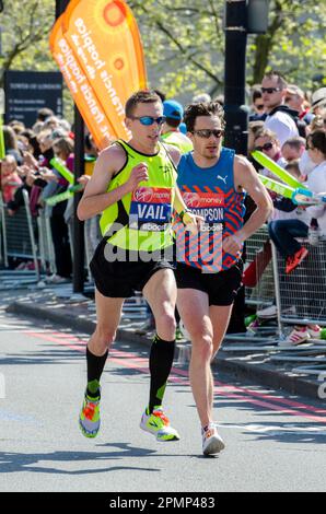 Ryan Vail e Chris Thompson gareggiano nella London Marathon 2014, passando attraverso Tower Hill vicino alla Tower of London, UK. Foto Stock