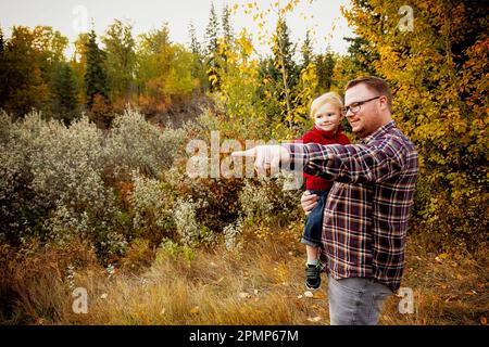 Ritratto di un padre con suo figlio giovane, che esplora l'aria aperta in un parco in autunno; Edmonton, Alberta, Canada Foto Stock