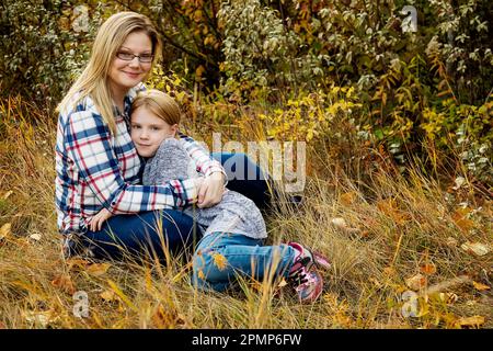 Ritratto all'aperto di una madre con sua figlia in abbraccio; Edmonton, Alberta, Canada Foto Stock