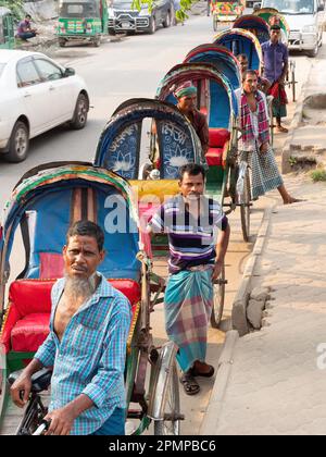 Conducenti di risciò in attesa di passeggeri a Dhaka, Bangladesh. Foto Stock