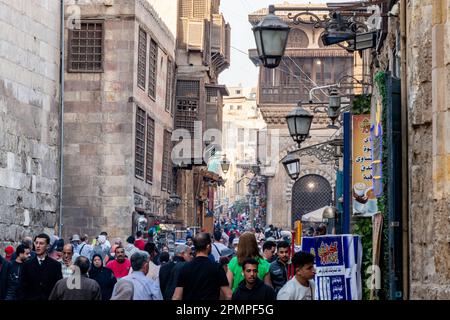 Gente che cammina attraverso un trafficato bazar del mercato Khan el-Khalil al Cairo islamico, in Egitto Foto Stock