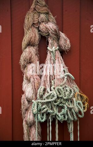 Rete da pesca appesa su un muro di un edificio in un villaggio di pescatori in Norvegia; Lovund Island, Norvegia Foto Stock