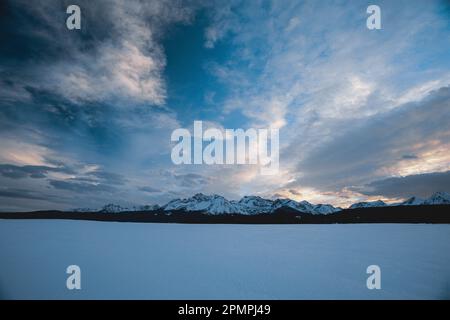 Le nuvole riempiono il cielo sulla neve Sawtooth Range, Idaho, USA; Stanley, Idaho, Stati Uniti d'America Foto Stock