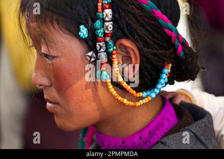 Profilo di una donna con accessorio per la testa al mercato Borkhar; Lhasa, Tibet Foto Stock