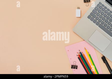 Idea di ritorno a scuola o concetto di giorno dell'insegnante. Matite e computer portatile, blocco note e flash drive, STUDIANDO IT e tecnologie digitali a scuola. Layout su f Foto Stock