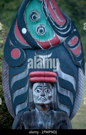 Palo totem in un cimitero sull'isola di Cormorant vicino all'isola di Vancouver, Haida Gwaii, BC, Canada; Cormorant Island, Haida Gwaii, Columbia Britannica, Canada Foto Stock