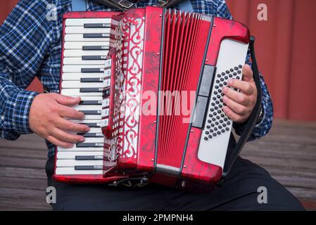 Primo piano di un uomo che suona una fisarmonica; Islanda Foto Stock