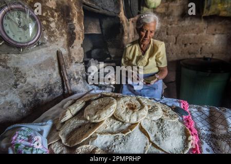 Anziana donna messicana che fa il pane nella sua cucina; Ejido Hidalgo, San Luis, Messico Foto Stock