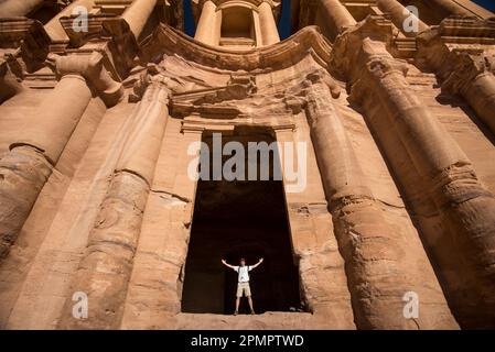 L'uomo si trova all'ingresso del monastero, o al Deir, a Petra; Petra, Giordania Foto Stock