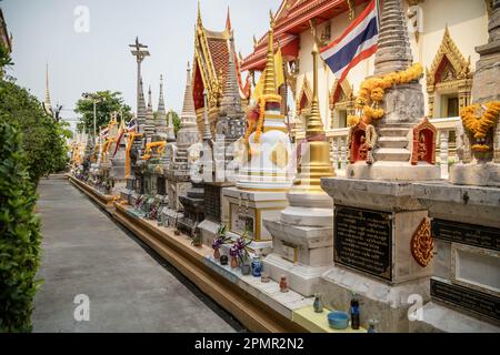 Il vicolo del cimitero del tempio di wat Sanam Nuea dove offerte e fiori sono stati collocati sulle tombe come parte dei rituali buddisti tradizionali il secondo giorno del Festival di Songkran nella città di Pak Kret, nella provincia di Nonthaburi. Il Songkran Festival è un tradizionale festival buddista che segna l'inizio del Capodanno tailandese, oltre ai rituali tradizionali sull'acqua e alle feste di strada, ci sono altre attività chiave a cui il popolo thailandese partecipa durante questa settimana come parte dei rituali buddisti tradizionali. Foto Stock