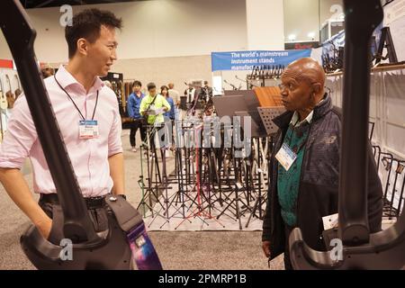 Anaheim, Stati Uniti. 14th Apr, 2023. Un conference goer (R, Front) visita lo stand di Shenzhen Dale Somatosensoriali Technology Co., Ltd. Durante la 2023 National Association of Music Merchants (NAMM) show all'Anaheim Convention Center di Anaheim, California, Stati Uniti, il 13 aprile 2023. Gli strumenti musicali prodotti in Cina stanno prendendo la luce in una mostra dell'industria musicale in corso nella California meridionale, attirando molta attenzione e riconoscimenti da parte di clienti e distributori stranieri. Credit: Zeng Hui/Xinhua/Alamy Live News Foto Stock