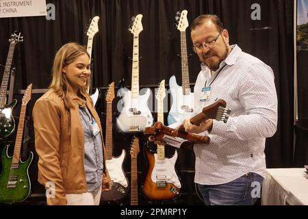 Anaheim, Stati Uniti. 14th Apr, 2023. Un convegno visiterà l'area espositiva delle aziende cinesi della contea di Zheng'an, nella provincia di Guizhou, nel sud-ovest della Cina, durante la fiera NAMM (National Association of Music Merchants) del 2023 presso l'Anaheim Convention Center di Anaheim, California, negli Stati Uniti, il 13 aprile 2023. Gli strumenti musicali prodotti in Cina stanno prendendo la luce in una mostra dell'industria musicale in corso nella California meridionale, attirando molta attenzione e riconoscimenti da parte di clienti e distributori stranieri. Credit: Zeng Hui/Xinhua/Alamy Live News Foto Stock