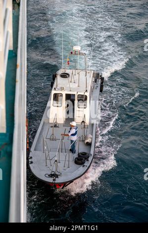 Cartagena, Colombia - 31 marzo 2023: Imbarcazione pilota a fianco di una nave da crociera che si prepara a riportare il pilota a terra. Foto Stock