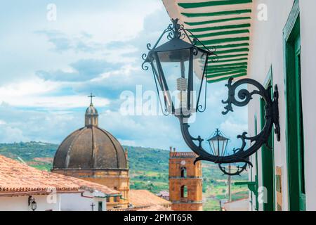 strada coloniale di barichara santander con lanterna in primo piano e cattedrale sullo sfondo Foto Stock