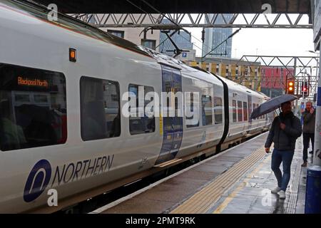 Servizio ferroviario Northern, EMU - unità elettrica multipla, su una piattaforma piovosa, alla stazione ferroviaria Manchester Oxford Road, Inghilterra, Regno Unito, M1 6FU Foto Stock