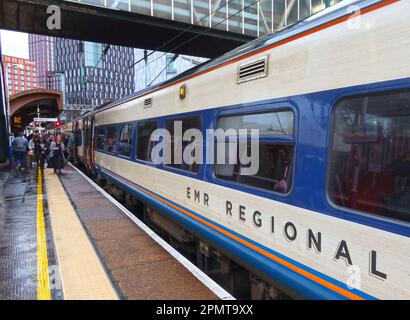 Servizio ferroviario regionale EMR, DMU - Diesel Multiple Unit, su piattaforma piovosa, presso la stazione ferroviaria Manchester Oxford Road, Inghilterra, Regno Unito, M1 6FU Foto Stock