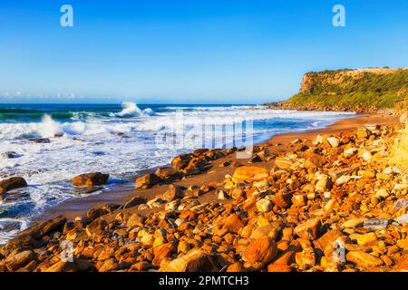 Panoramica spiaggia di sabbia rocciosa cava nella città spiaggia di Caves sulla costa del Pacifico dell'Australia. Foto Stock