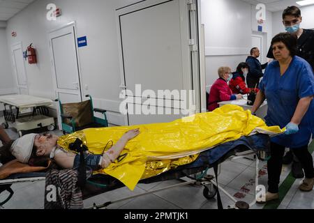 Sloviansk, Ucraina. 14th Apr, 2023. Una ragazza ferita è vista su una barella su ruote che si trasferisce all'ospedale di Sliviansk. Le truppe russe hanno attaccato la città Ucraina orientale Sliviansk sul grande venerdì ortodosso orientale. I funzionari hanno affermato che è il più grande attacco di razzo da mesi, causando almeno 8 morti e 21 feriti, compresi i bambini e molti edifici distrutti. Ufficiale ha anche detto che almeno 7 missili sono stati sparati durante il venerdì pomeriggio. Credit: SOPA Images Limited/Alamy Live News Foto Stock