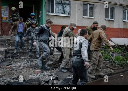 Sloviansk, Ucraina. 14th Apr, 2023. Funzionari militari e vigili del fuoco trasportano una ragazza ferita salvata dalle macerie a Sloviansk. Le truppe russe hanno attaccato la città Ucraina orientale Sliviansk sul grande venerdì ortodosso orientale. I funzionari hanno affermato che è il più grande attacco di razzo da mesi, causando almeno 8 morti e 21 feriti, compresi i bambini e molti edifici distrutti. Ufficiale ha anche detto che almeno 7 missili sono stati sparati durante il venerdì pomeriggio. Credit: SOPA Images Limited/Alamy Live News Foto Stock