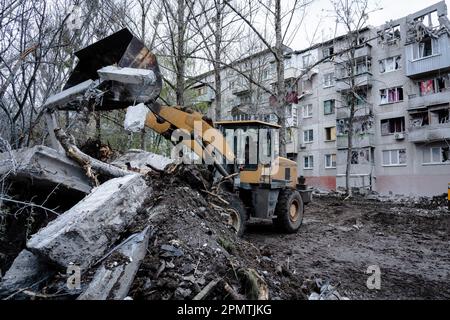 Sloviansk, Ucraina. 14th Apr, 2023. Si vede un trattore che solleva le macerie nel sito danneggiato a Sloviansk. Le truppe russe hanno attaccato la città Ucraina orientale Sliviansk sul grande venerdì ortodosso orientale. I funzionari hanno affermato che è il più grande attacco di razzo da mesi, causando almeno 8 morti e 21 feriti, compresi i bambini e molti edifici distrutti. Ufficiale ha anche detto che almeno 7 missili sono stati sparati durante il venerdì pomeriggio. Credit: SOPA Images Limited/Alamy Live News Foto Stock