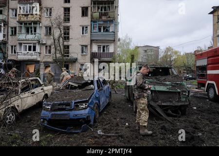 Sloviansk, Ucraina. 14th Apr, 2023. Un soldato si trova accanto ad alcune auto danneggiate in un sito colpito dal razzo di Sloviansk. Le truppe russe hanno attaccato la città Ucraina orientale Sliviansk sul grande venerdì ortodosso orientale. I funzionari hanno affermato che è il più grande attacco di razzo da mesi, causando almeno 8 morti e 21 feriti, compresi i bambini e molti edifici distrutti. Ufficiale ha anche detto che almeno 7 missili sono stati sparati durante il venerdì pomeriggio. (Foto di Ashley Chan/SOPA Images/Sipa USA) Credit: Sipa USA/Alamy Live News Foto Stock