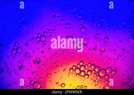 Sfondo colorato con gocce d'acqua e d'olio e sfondo giallo e blu Foto Stock