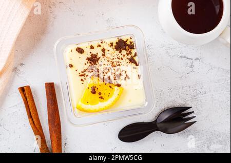 Dessert tiramisù in una scatola di plastica con forchetta su fondo di cemento. Foto di alta qualità Foto Stock