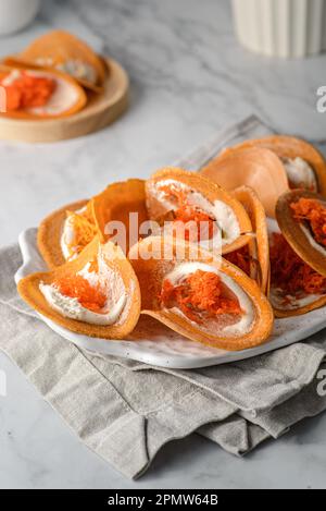 Khanom Buang Thai dessert di croccante e meringa. è composto da waffle croccanti e meringa a base di albume e zucchero con tuorlo d'uovo e coprimaterasso di cocco Foto Stock