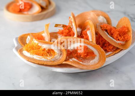 Khanom Buang Thai dessert di croccante e meringa. è composto da waffle croccanti e meringa a base di albume e zucchero con tuorlo d'uovo e coprimaterasso di cocco Foto Stock