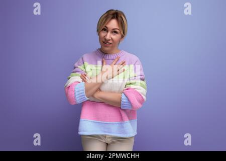 carino timido blondie giovane donna su sfondo viola con spazio copia Foto Stock