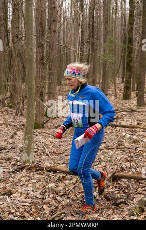 Grodno, Bielorussia - 25 Marzo, 2023: Donne caucasiche adulte in una foresta durante l'esercizio in Gro orienteering all'aperto Foto Stock