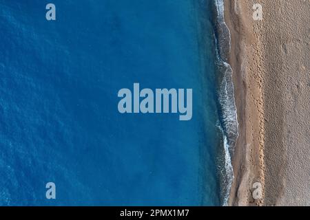 Scopri la bellezza di una spiaggia tranquilla e appartata con questa immagine ipnotica dall'alto Foto Stock