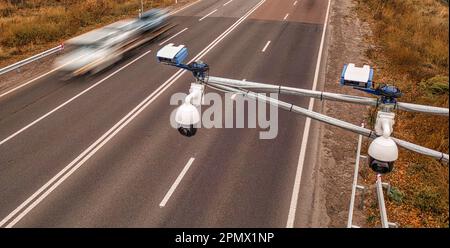 Una telecamera di monitoraggio del traffico montata in alto sopra l'autostrada cattura il movimento dei veicoli al di sotto, tenendo d'occhio la velocità del conducente per evitare accidenti Foto Stock