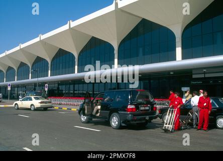 Gli Emirati Arabi Uniti al di fuori dell'aeroporto di Dubai lavorano con Sack Barrows per aiutare a spostare bagagli pesanti Foto Stock