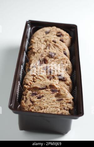 Biscotti con scaglie di cioccolato in confezioni di plastica su sfondo bianco. Messa a fuoco selettiva Foto Stock