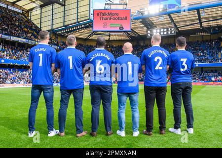 USO EDITORIALE SOLO ex giocatori di Chelsea Gary Cahill, Jimmy Floyd Hasselbaink e Eiður Guðjohnsen (camicie denominate) e fan di Chelsea (l-r) Marcus Cuthbert, Carlo capelli, E Fabio Agostini mostra il numero di assistenza di 24 ore dei Samaritani 116 123 stampato sul retro delle loro camicie durante il lancio della campagna TalkMoreThanFootball da tre, sponsor dei Samaritani, durante l'intervallo di tempo tra Chelsea e Brighton a Stamford Bridge, Londra. Data immagine: Sabato 15 aprile, 2023. Foto Stock